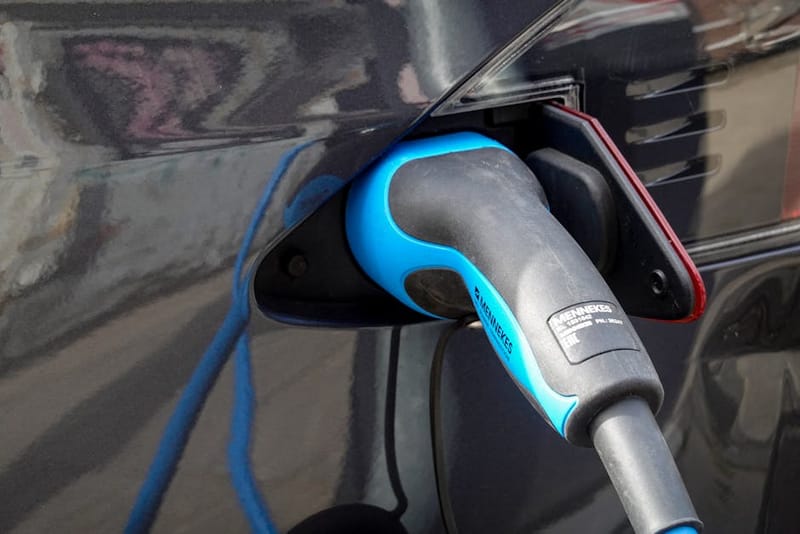 Close-up of a Type 2 Mennekes connector being plugged into an electric vehicle's charging port