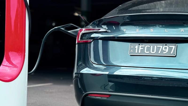 Close-up of an EV charging port mid-session, illustrating an OVO Charge Anytime smart-scheduled charging top-up