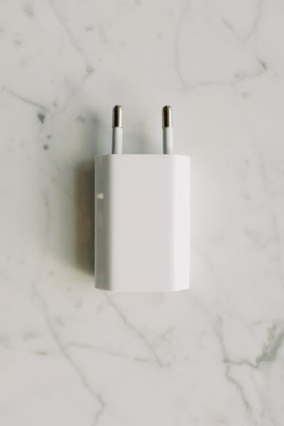 Compact wall-mounted Easee-style home EV charger on a white residential exterior wall