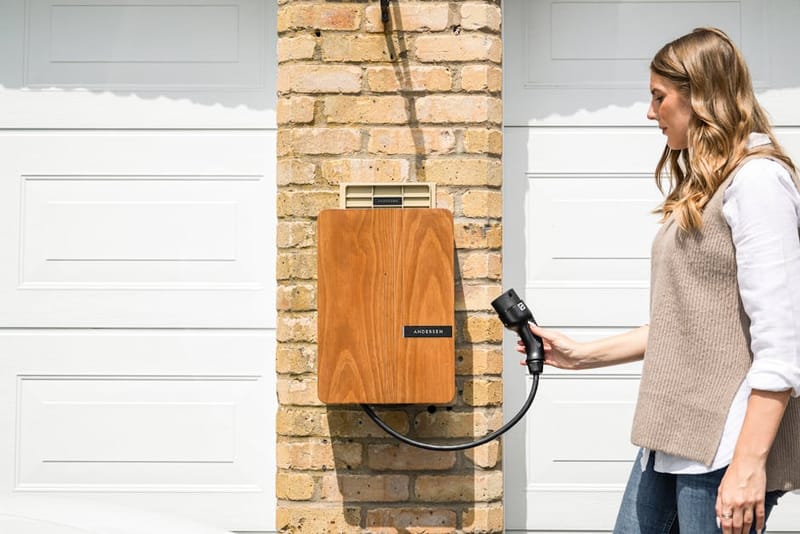 Andersen Quartz home EV charger with a wood-effect front panel mounted on an exterior wall